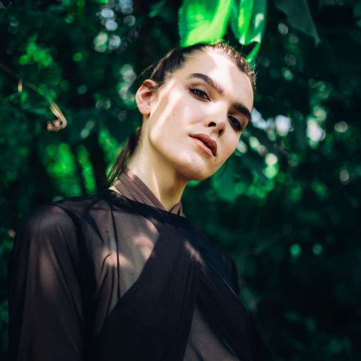 mulher vestindo blusa transparente sob a planta de folhas verdes puzzle online