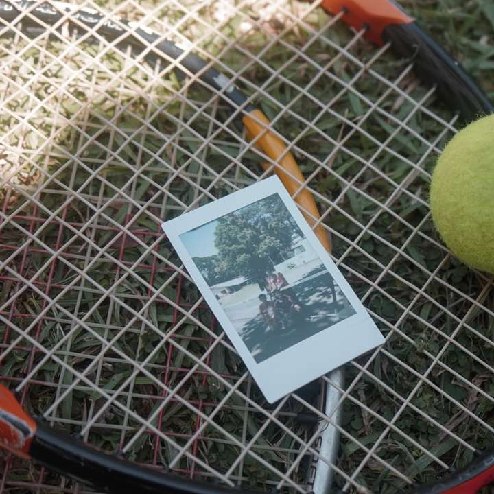 Pelota de tenis verde junto a la tarjeta blanca y negra rompecabezas en línea