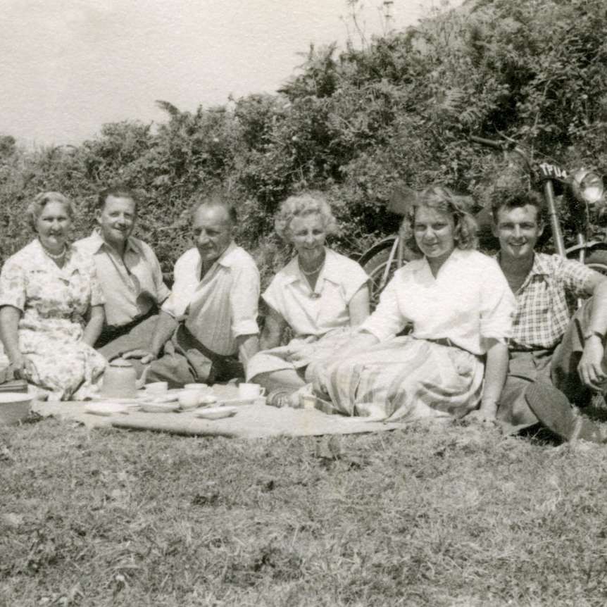 grijswaardenfoto van een groep mannen die op gras zitten schuifpuzzel online