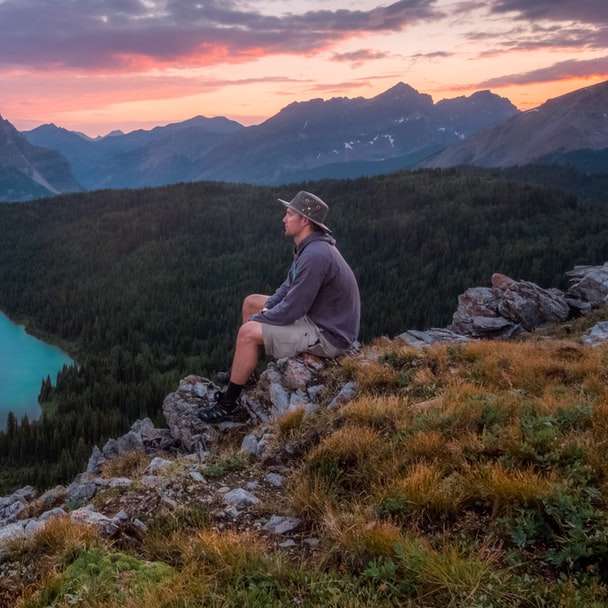 hombre mirando en la montaña sentado sobre una roca puzzle deslizante online