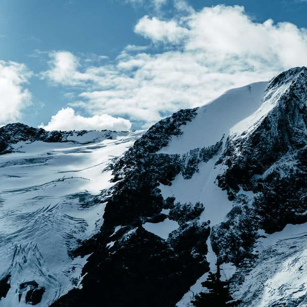 pokryta śniegiem skalista góra w ciągu dnia puzzle przesuwne online