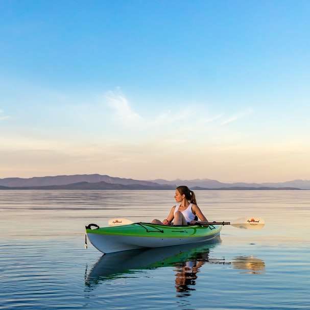 woman on green and white kayak holding yellow oar online puzzle