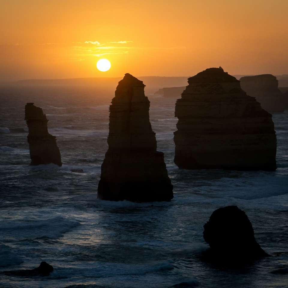 photograph of rock formation on sea during golden hour sliding puzzle online