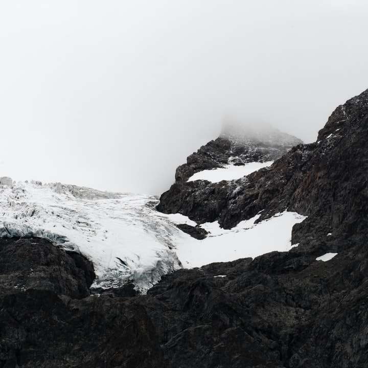 svarta berg täckta med snö glidande pussel online