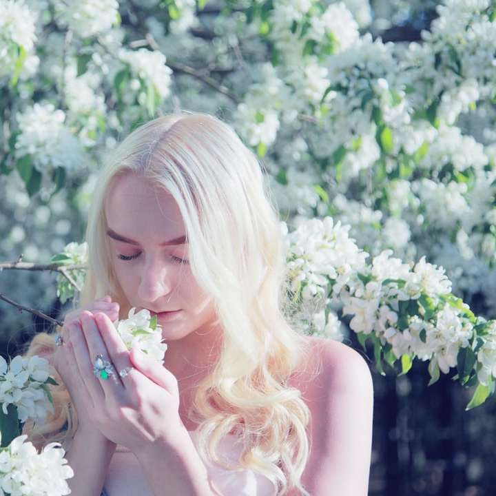 женщина нюхает цветок в дневное время раздвижная головоломка онлайн