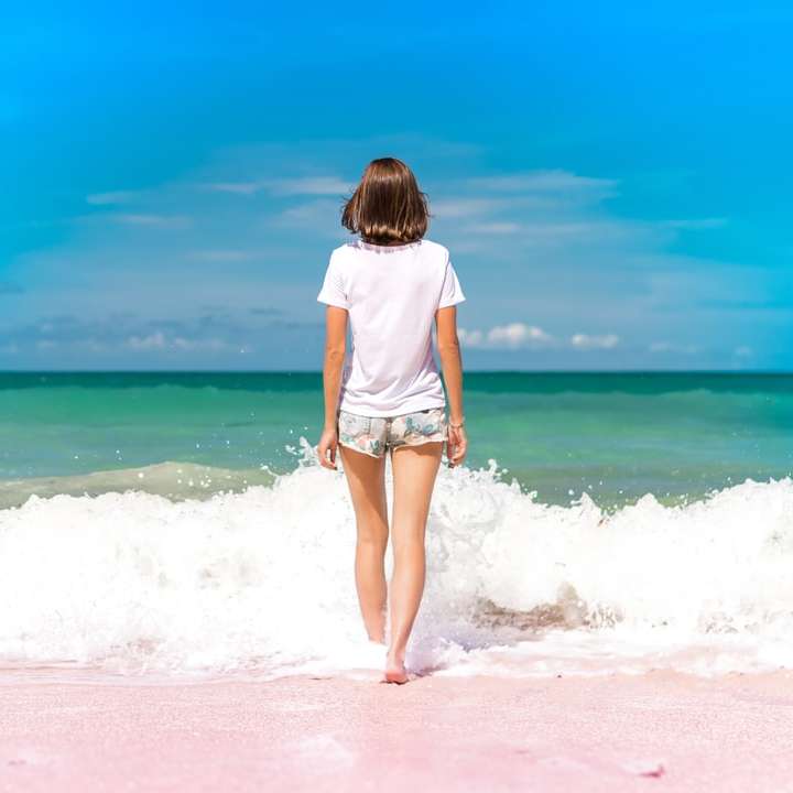 fotografia de lapso de tempo de mulher em frente às ondas do mar puzzle deslizante online