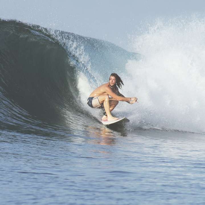 hombre surfeando con olas grandes rompecabezas en línea