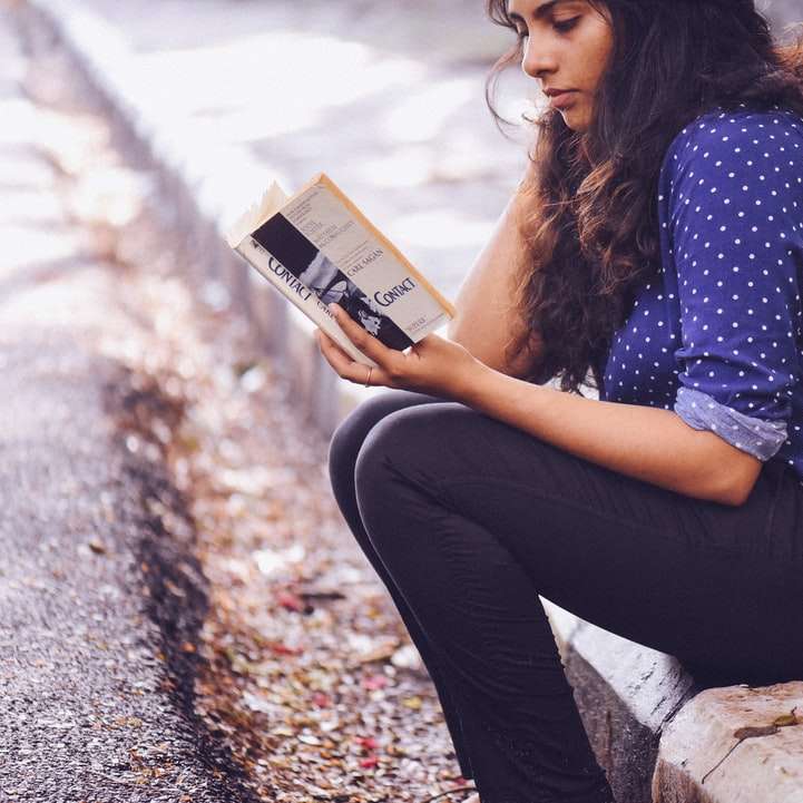 woman sitting on gutter reading book online puzzle