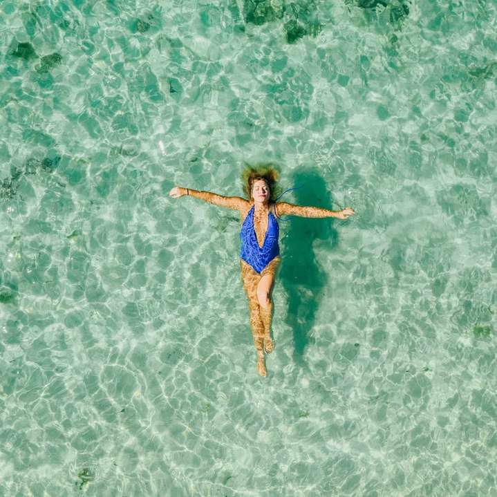 woman wearing blue one-piece bikini on the body of water sliding puzzle online