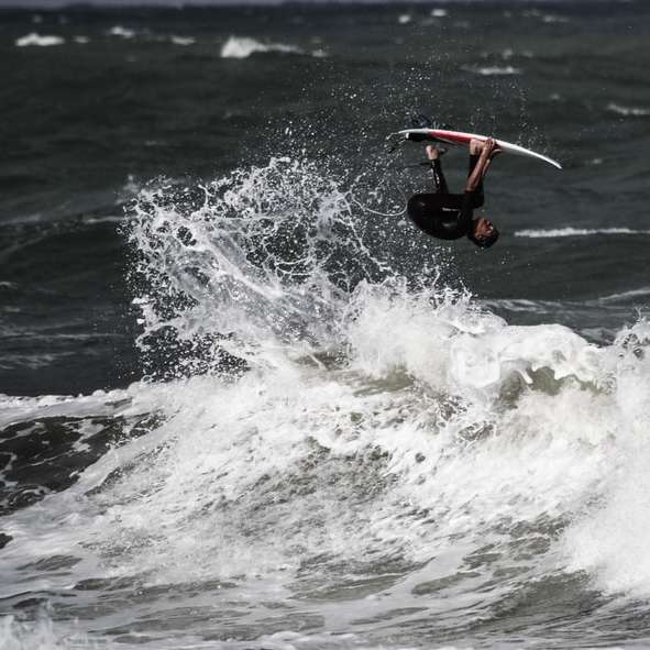 persona que practica surf en las olas del mar durante el día rompecabezas en línea