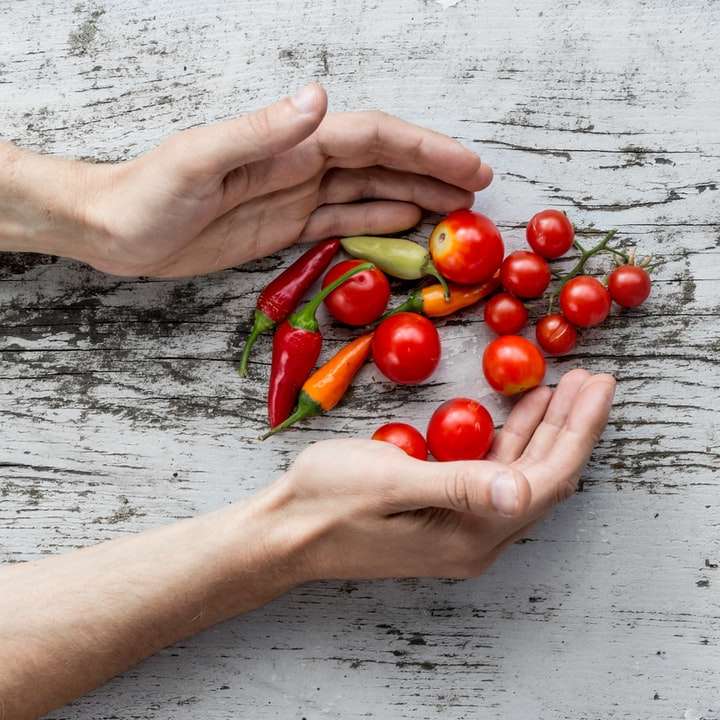 рука людини збирається отримати помідори черрі та болгарський перець онлайн пазл