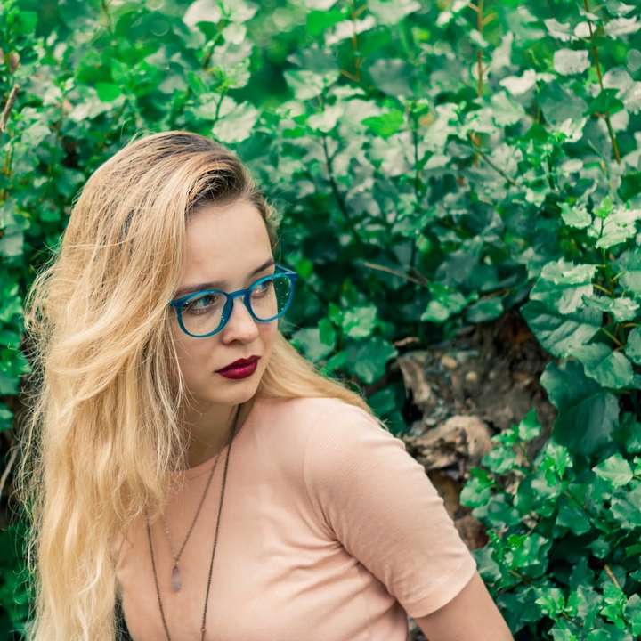 kvinna som bär glasögon som står nära växten Pussel online