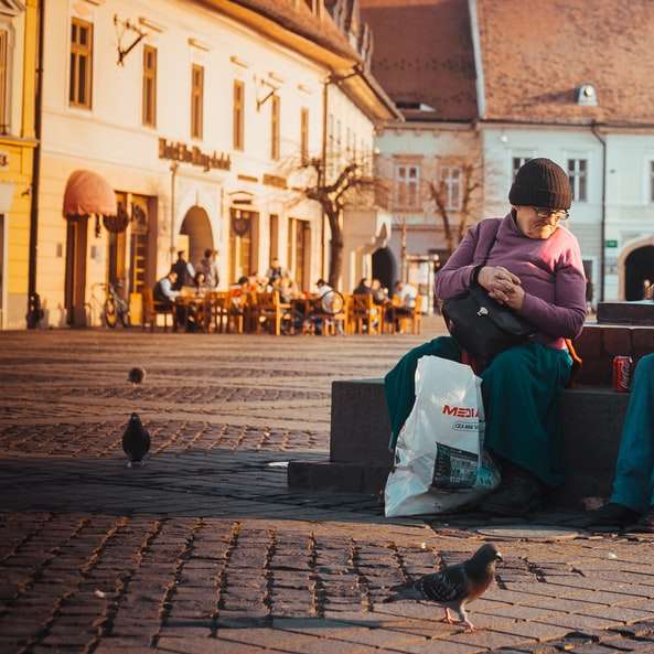 Ludzie siedzący na placu miejskim puzzle online