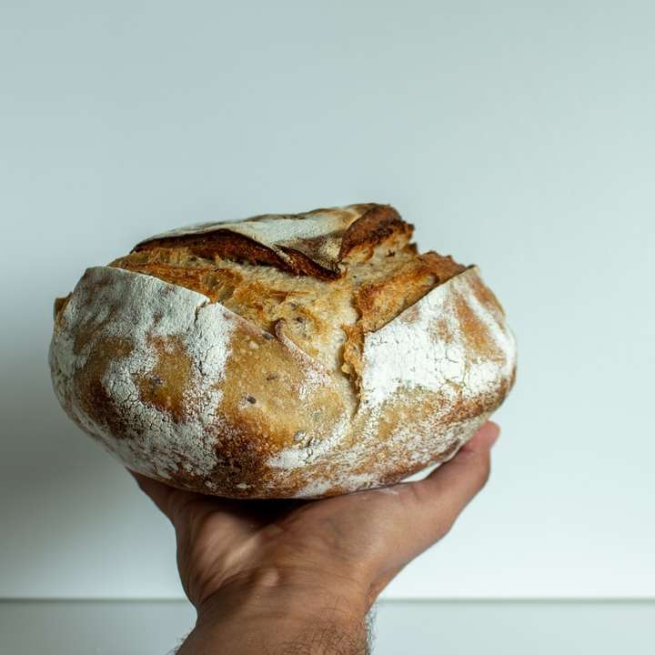 Bochenek chleba na zakwasie trzymać w dłoni puzzle online