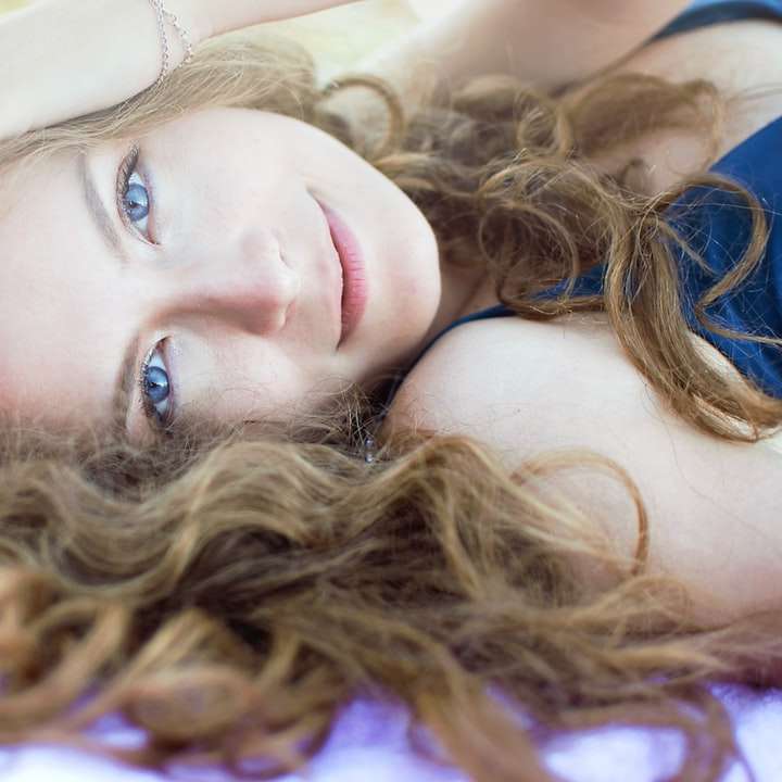 Femme en débardeur violet couché sur textile bleu puzzle coulissant en ligne