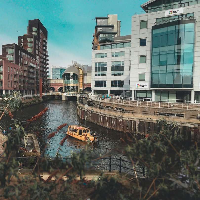 beige boat on body of water between buildings sliding puzzle online