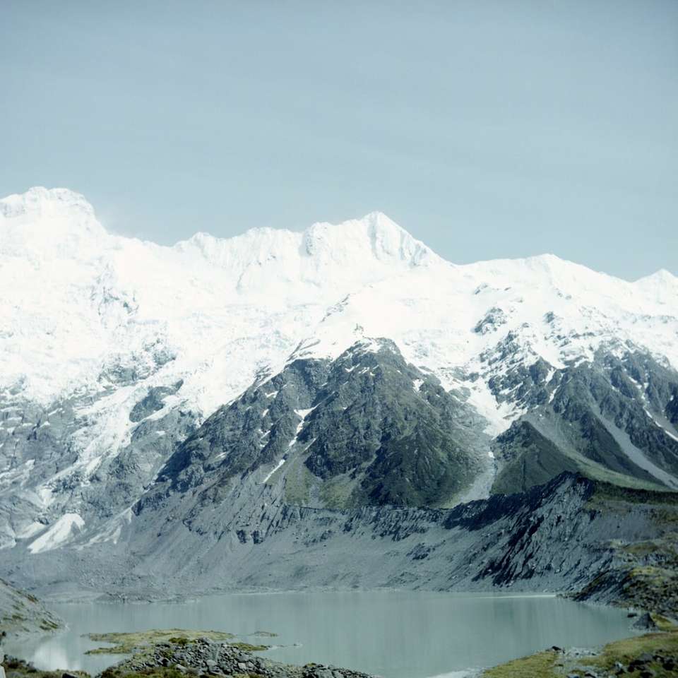 hora pokrytá sněhem ukazující jezero během dne posuvné puzzle online