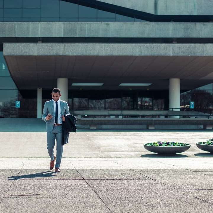 człowiek idący trzymając czarny płaszcz puzzle online