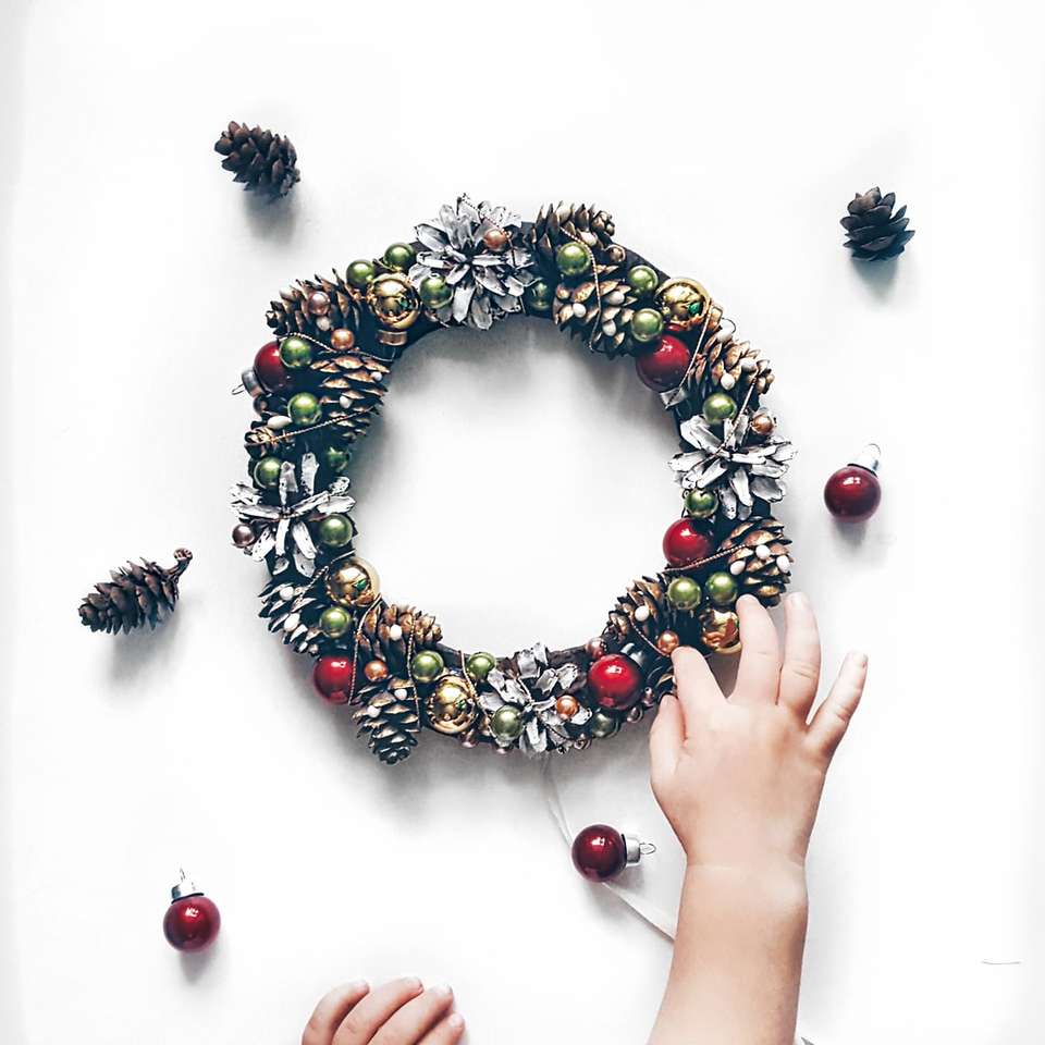person making bauble and pinecone wreath online puzzle