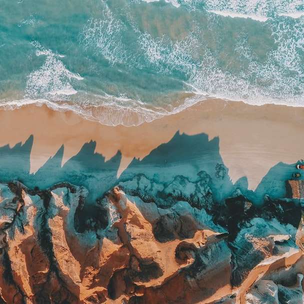 hnědé skalnaté pobřeží během dne online puzzle