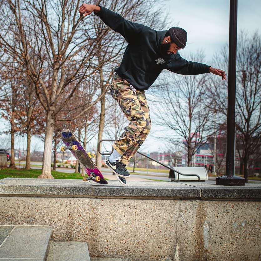 homem de jaqueta preta e calça marrom pulando no skate puzzle online