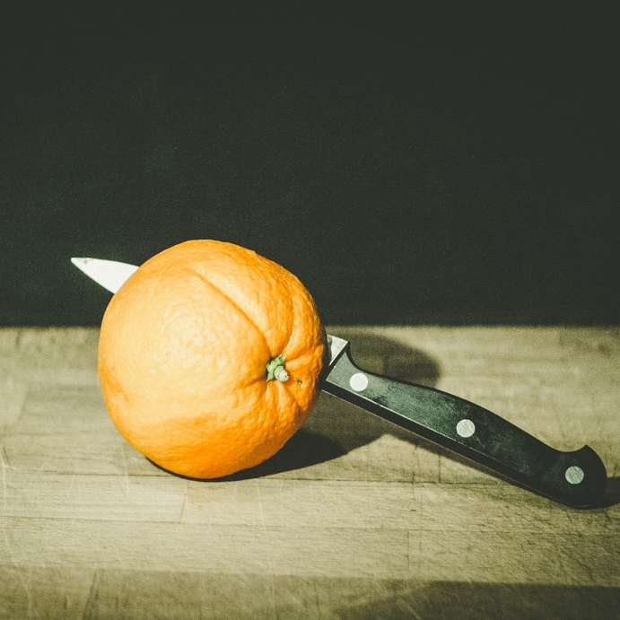 Orangenfrucht und graues und schwarzes Messer Online-Puzzle