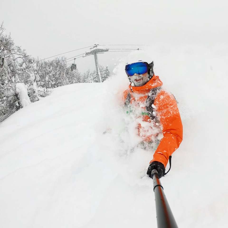 persona vestida con chaqueta naranja en la nieve rompecabezas en línea