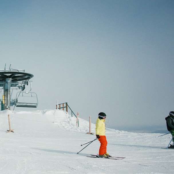 Personas vestidas con equipos de esquí de nieve en el campo de nieve rompecabezas en línea