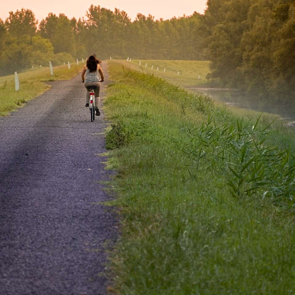 kobieta, jazda na rowerze po wiejskiej drodze puzzle online