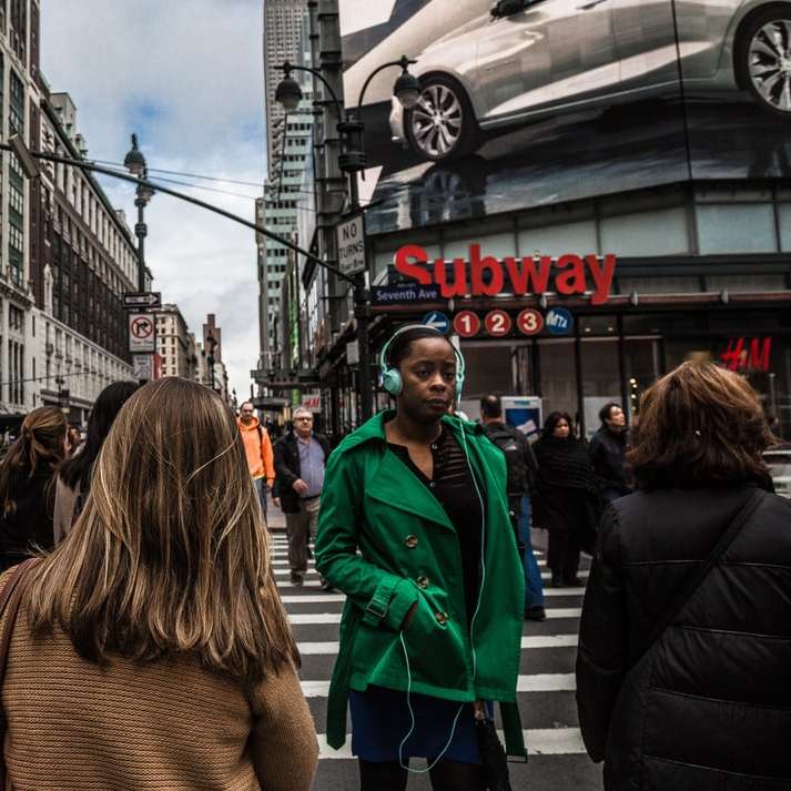 Frau, die grüne Jacke trägt, die auf der Fußgängerzone geht Schiebepuzzle online