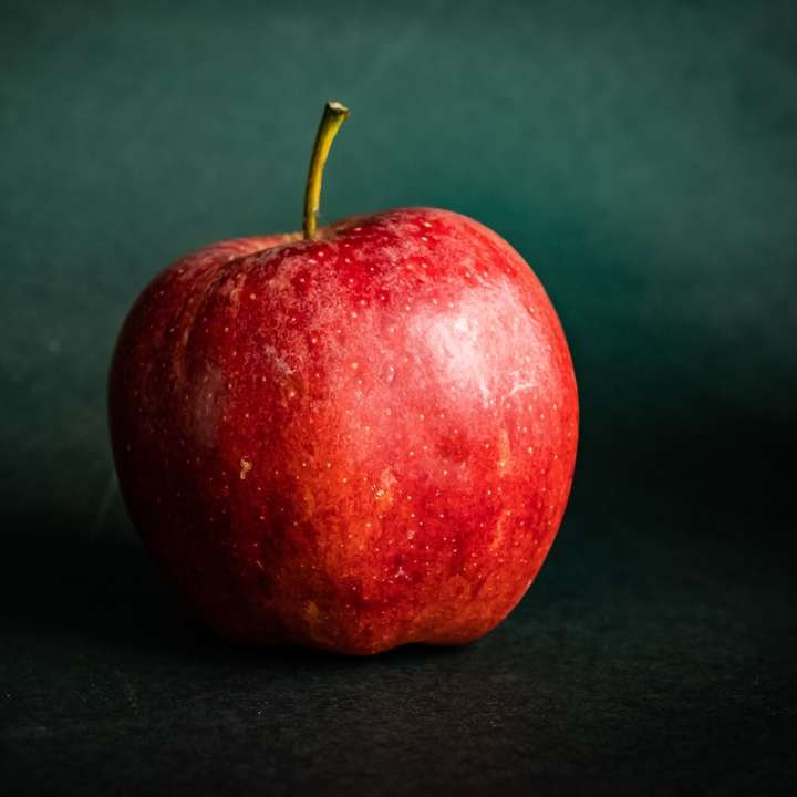 röd äppelfrukt på svart textil glidande pussel online