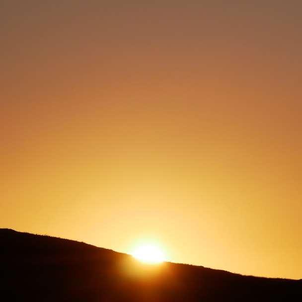Schattenbild der Leute oben auf Hügel während Sonnenuntergang Schiebepuzzle online