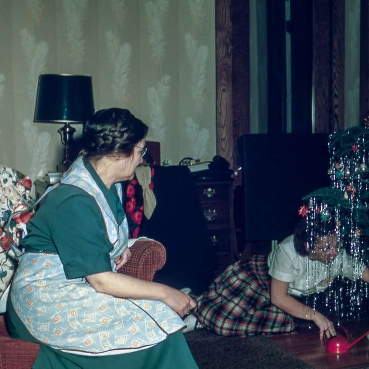 クリスマスツリーの下に座っている女性 オンラインパズル