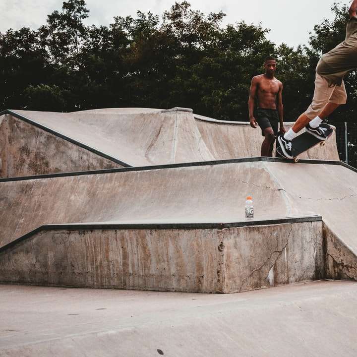 man slijpen skateboard op oprit richel in de buurt van de mens schuifpuzzel online