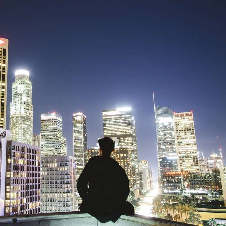 Mann sitzt auf dem Dach während der Nacht Online-Puzzle