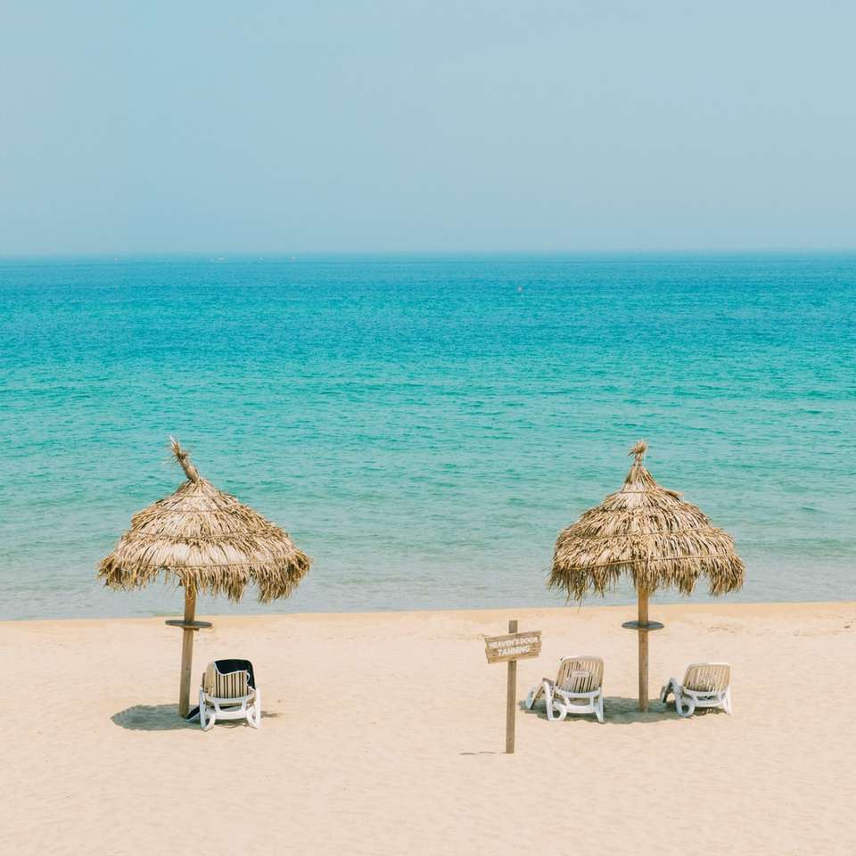 Chaises longues de plage en bois marron sur la plage pendant la journée puzzle en ligne