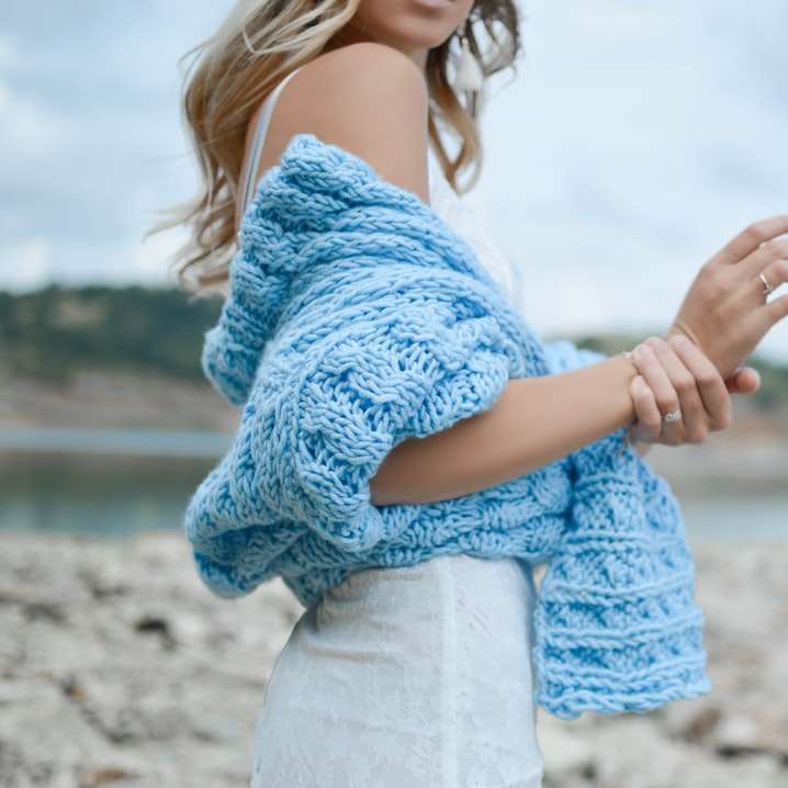 Femme portant un haut au crochet bleu sarcelle et une jupe blanche puzzle coulissant en ligne