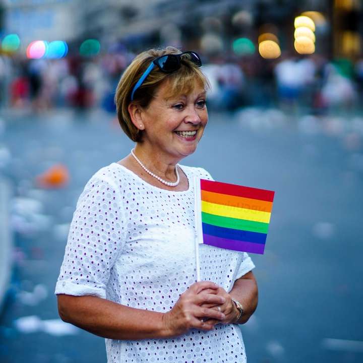 uśmiechnięta kobieta trzyma flaglet LGBT puzzle przesuwne online