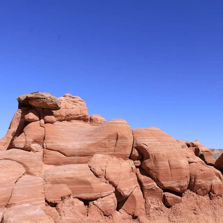 bruine rotsformatie onder blauwe hemel overdag schuifpuzzel online