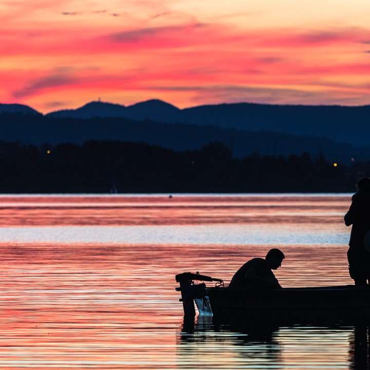дві людини стоять на човні на водоймі онлайн пазл
