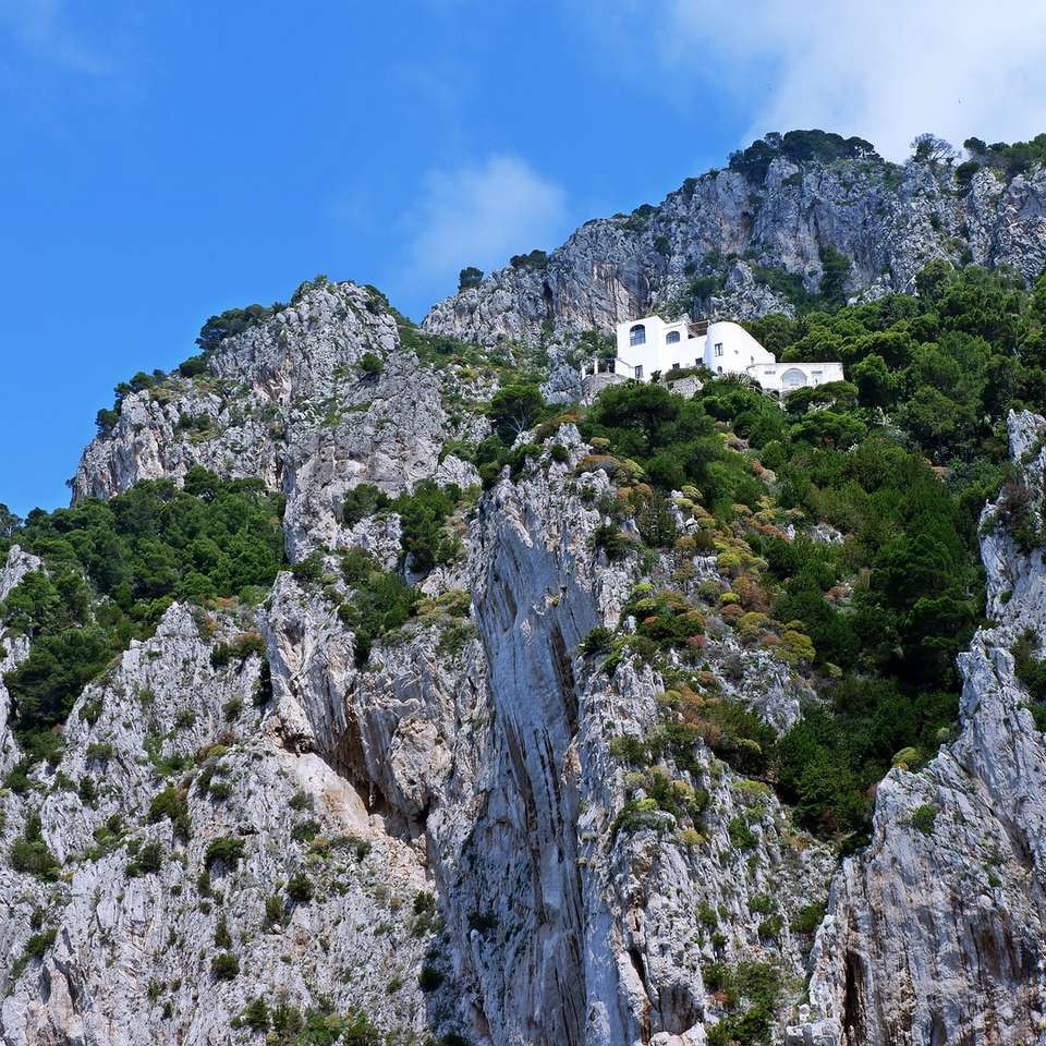 wit betonnen huis op de top van de berg schuifpuzzel online