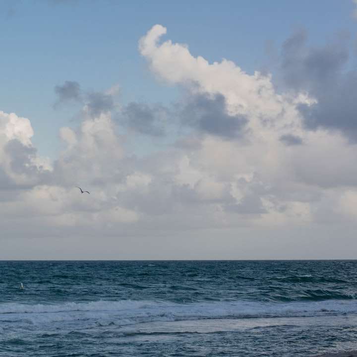 синьо море под синьо небе и бели облаци през деня плъзгащ се пъзел онлайн