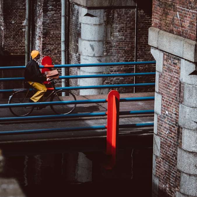 Mann, der Fahrrad auf grauer Betonbrücke während des Tages reitet Online-Puzzle