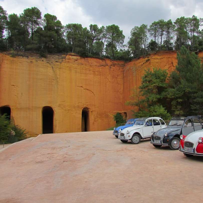 бели и червени коли, паркирани до кафява бетонна стена плъзгащ се пъзел онлайн