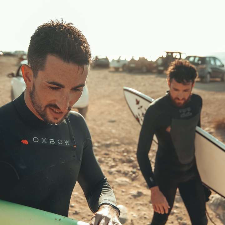2 mannen met surfplanken in strand online puzzel
