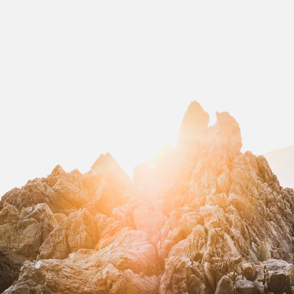 montagna rocciosa marrone sotto il cielo bianco durante il giorno puzzle scorrevole online