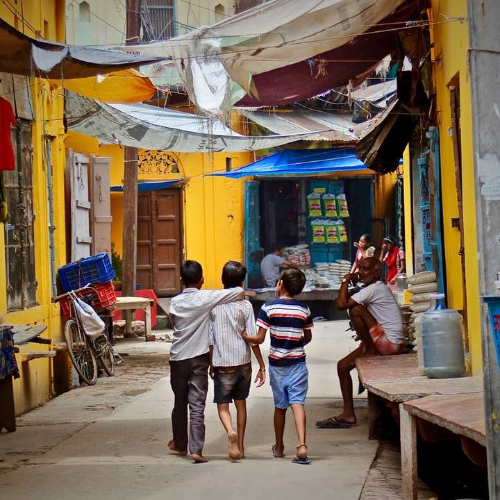 τρία αγόρια περπατώντας ανάμεσα σε κτίρια κατά τη διάρκεια της ημέρας συρόμενο παζλ online