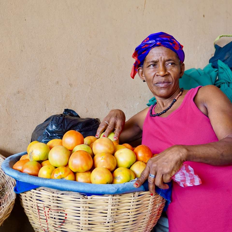 Mujer en camiseta rosa sentada junto a frutas redondas amarillas rompecabezas en línea