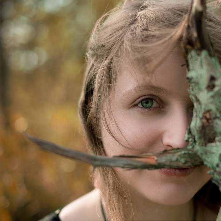 момиче в бял потник, държащ зелен клон на дървото плъзгащ се пъзел онлайн