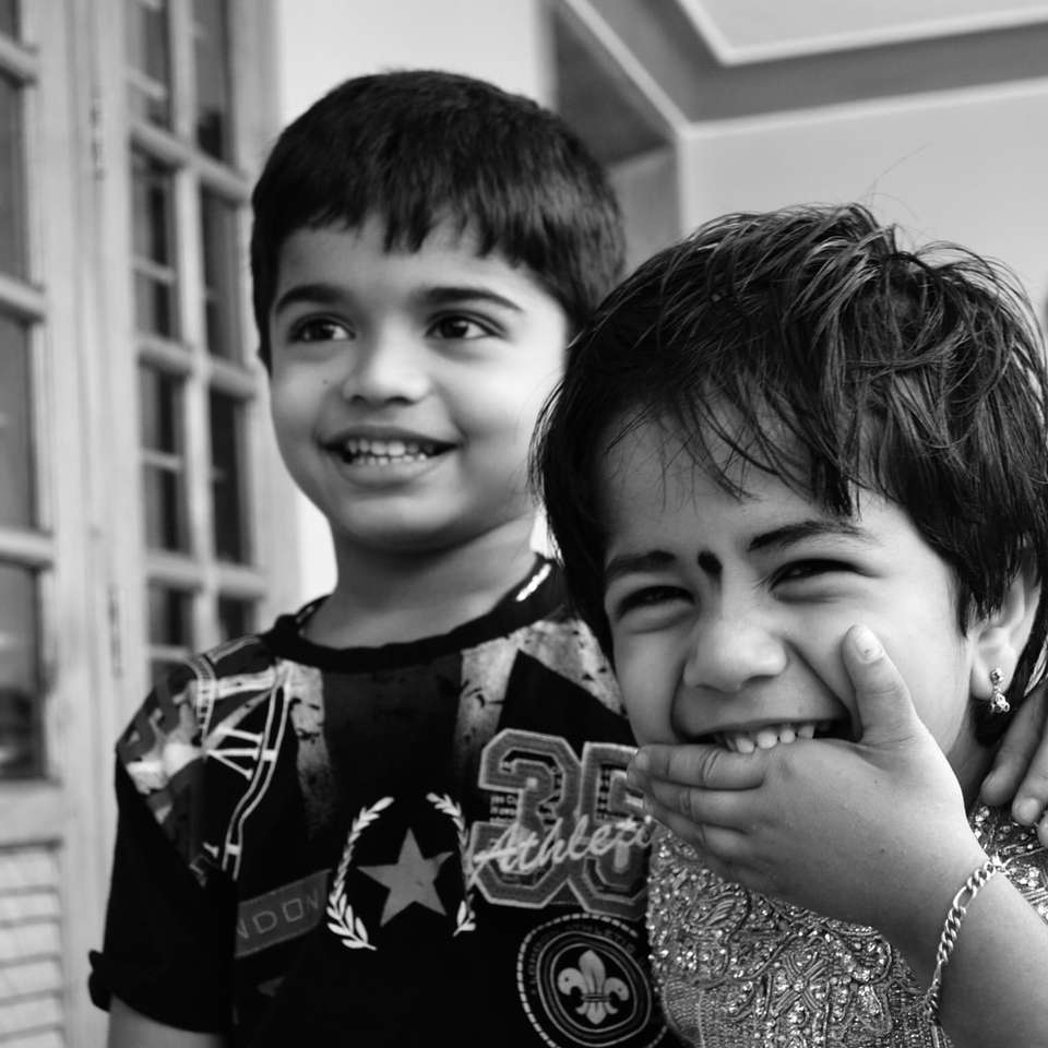 gråskalefoto av 2 pojkar som ler glidande pussel online
